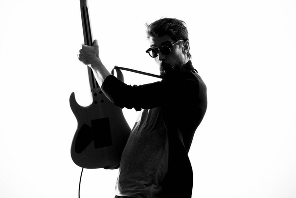 Человек с гитарной музыкой развлекает современных исполнителей солнцезащитными очками - Фото, изображение