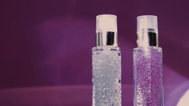 Make-up-Basis und Serum-Gel als luxuriöse Hautpflegeprodukte und glänzende Lichteffekte auf lila Hintergrund, Hautpflege-Routine für Gesichtskosmetik und Beauty-Marke - Filmmaterial, Video