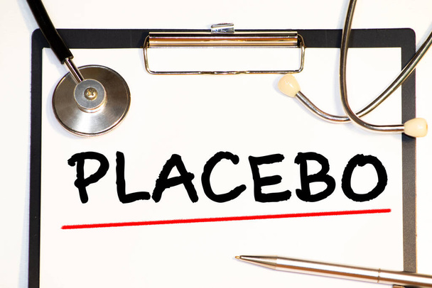 Placebo-Effekt Wörter auf medizinischer blauer Mappe mit Patientenakten, Pillen und Stethoskop auf Hintergrund geschrieben - Foto, Bild