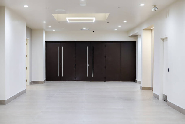 Empty long corridor and big doors. Office space. Business building. - Photo, Image
