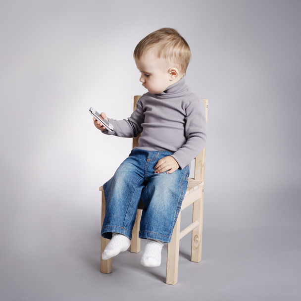 Ребенок с помощью мобильного телефона - Фото, изображение