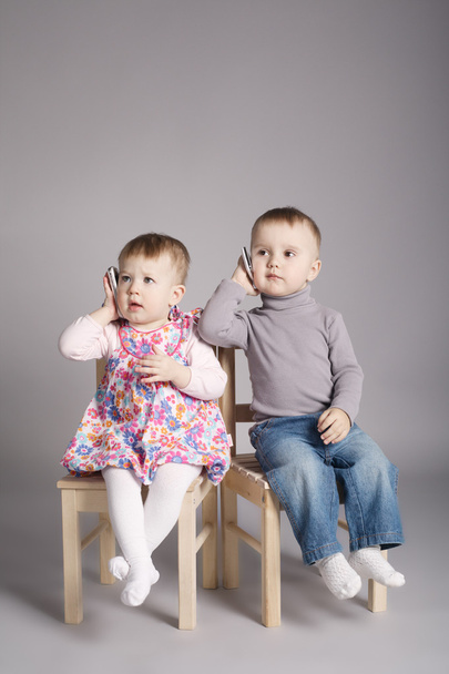 boy and girl playing with mobile phones - Φωτογραφία, εικόνα