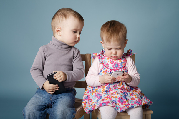 boy and girl playing with mobile phones - Фото, зображення