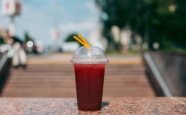 Red raspberry drink in a plastic glass with a straw - Photo, Image
