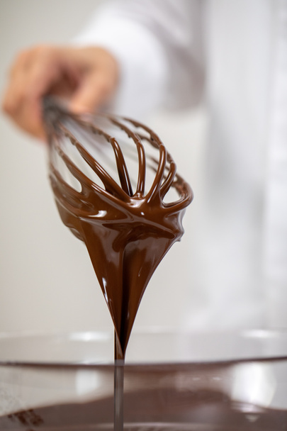 Zbliżenie leje smaczne ciemne stopione czekolady na trzepaczki, izolowane białe tło - Zdjęcie, obraz