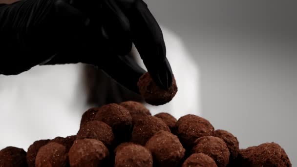 Chefs χέρι σε μαύρο γάντι βάζει καραμέλα τρούφας πάνω από γλυκά σωρό αργή mo - Πλάνα, βίντεο