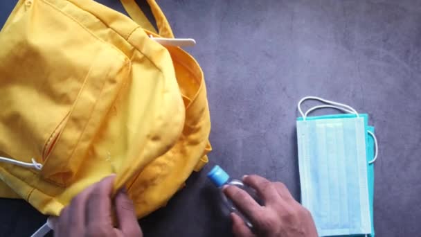 Student schooltas met ontsmettingsmiddel, een gezichtsmasker. - Video