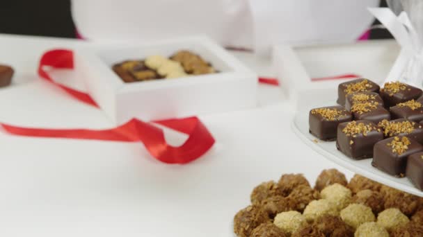 Κοντινό πλάνο σοκολατένιο κουτί δώρου συσκευασίας από χειροποίητα νόστιμα σοκολατάκια - Πλάνα, βίντεο