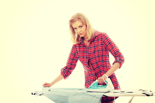 Young woman ironing - Foto, afbeelding