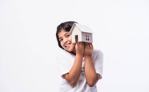 concepto de hogar y familia - india asiática niña sosteniendo papel casa modelo sobre fondo blanco - Foto, imagen