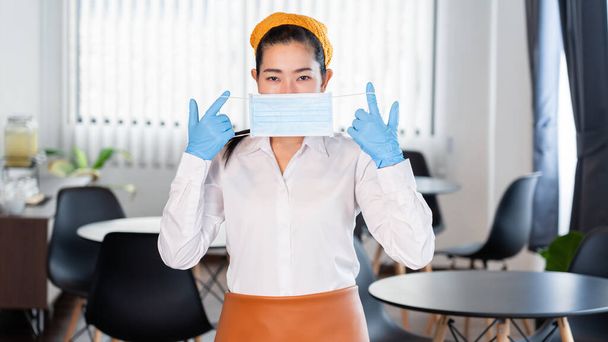 attractive asian waitress wear face mask to protection epidemic virus outbreak coronavirus disease COVID-19 in her restaurant, new normal concept - Fotoğraf, Görsel
