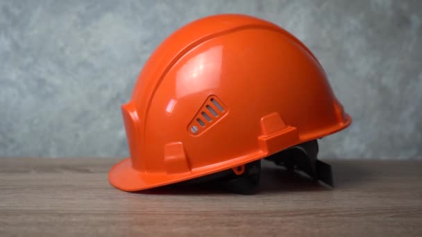 orange helmet is lying on a wooden table - Footage, Video