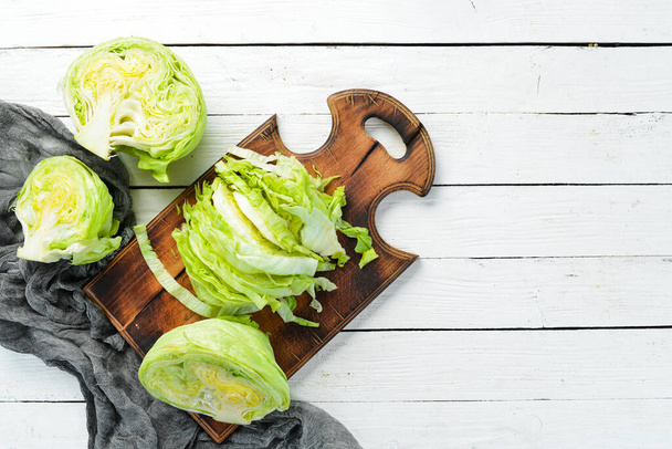 Lettuce on a white wooden background. Green healthy food. Iceberg lettuce. Top view. Free copy space. - Fotoğraf, Görsel