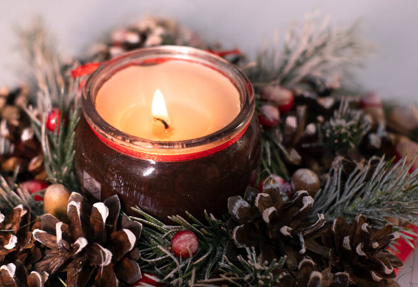  Kerstdecor stervormig gemaakt van boomtak met nieuwjaarsspeelgoed en een kaars erin - Foto, afbeelding
