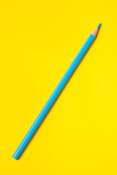 diagonal blue sharp wooden pencil on a bright yellow background, isolated, copy space, mock up - Foto, Imagen