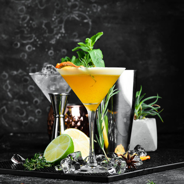 Alcoholic cocktail with sea buckthorn and orange with liqueur in a glass. On a black stone background. Menu bar. - Foto, Imagen