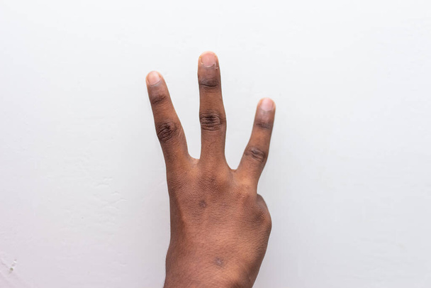 Рука хлопчика, що показує три символи жестів, ізольовані на білому тлі. Гештальт номер 3. Номер три на мові жестів. Розраховуючи три поняття. Три пальці вгору
. - Фото, зображення