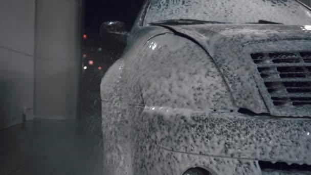 Ο άνθρωπος ποτίζει το αυτοκίνητο με αφρό - Πλάνα, βίντεο