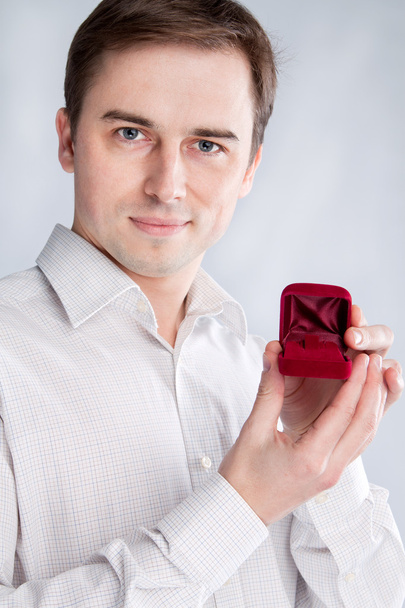 Guy holds jewelry box near the face - 写真・画像