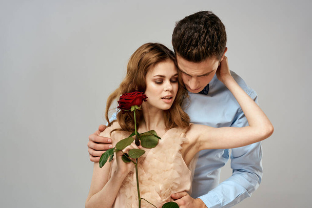 Young couple hugs romance dating lifestyle relationship light background red rose - Photo, Image