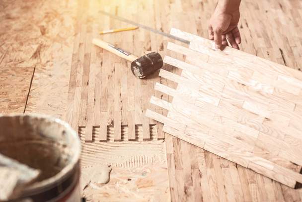 Wood Flooring Installation. worker installing wood parquet. Carpenter on work putting wood parquet pieces. - Photo, Image