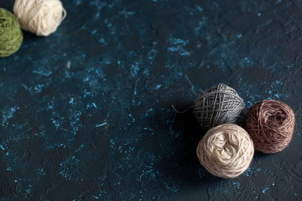 Color balls skein of wool yarn for crochet and knit on dark blue texture putty concrete. Flatlay image with space for text. - Photo, Image