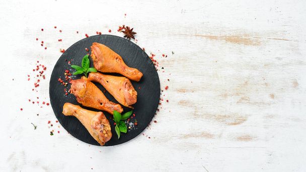 Smoked chicken drumsticks with spices and herbs. Top view. Free space for text. - Foto, Bild