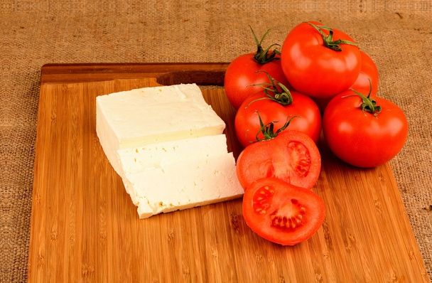 cheese and tomatoes on a cutting board - Φωτογραφία, εικόνα