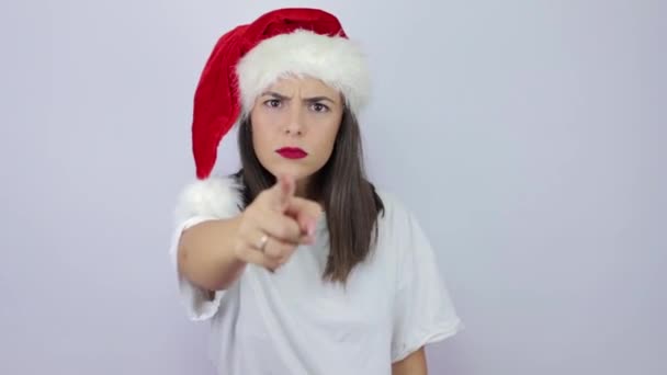Wees voorzichtig. Strikte en ernstige jonge mooie vrouw dragen Santa Claus hoed over geïsoleerde witte achtergrond waarschuwing, het maken van stapelen hand gebaar, uitschelden - Video