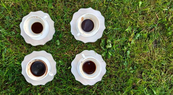 The cup of coffee on a morning grass image - Photo, Image