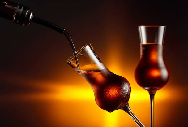 Verser une boisson alcoolisée dans un verre avec de la glace naturelle. Verres à la vapeur avec boisson alcoolisée forte. Espace de copie. - Photo, image