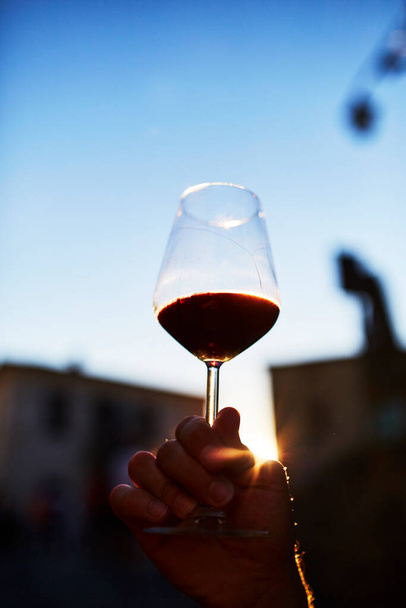 Un verre de vin rouge dans une main d'homme - Photo, image