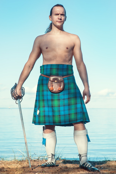 Scottish man with sword near the sea - Photo, Image