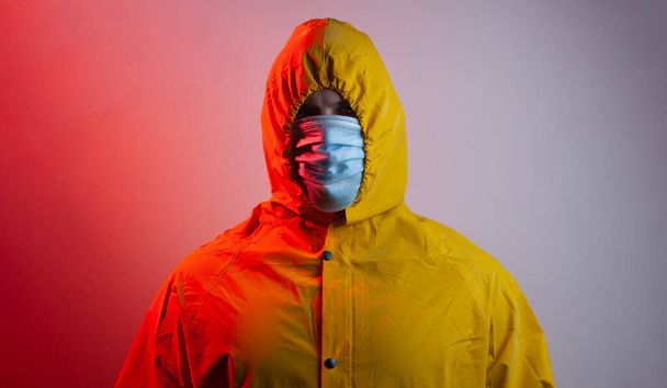 Virologist in a medical mask and yellow protective suit with a hood - Photo, Image