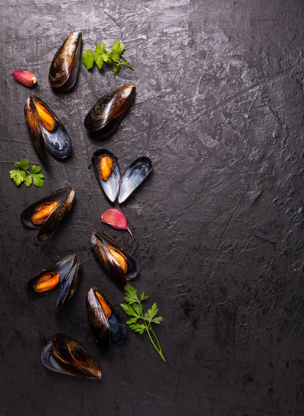 Boiled mussels with spices on dark background with copy space, vertical - Foto, imagen
