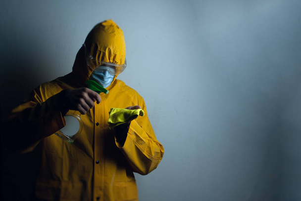 un empleado con un traje protector desinfecta la habitación - Foto, imagen