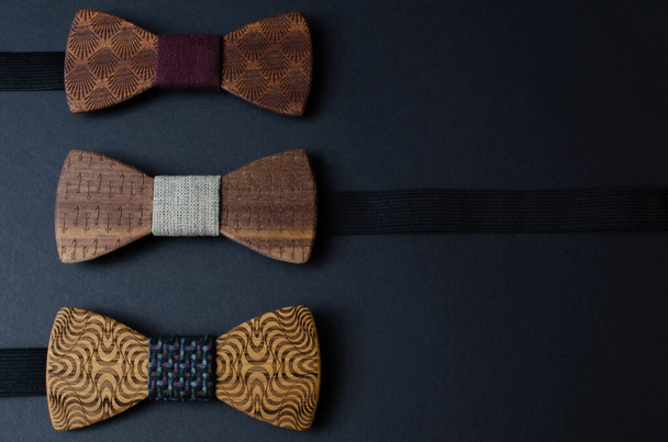 Sammlung von Fliege-Krawatten aus handgefertigtem Holz, auf schwarzem Hintergrund - Foto, Bild