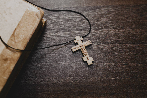 Wooden cross and old bible book on wooden table - Photo, Image