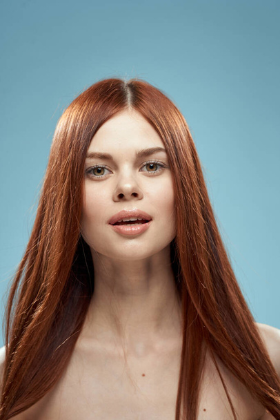 Gyönyörű barna hosszú haj meztelen vállak kozmetikumok varázsa egészségügyi kék háttér - Fotó, kép