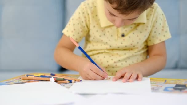 Küçük şirin çocuk kalemle resim çiziyor. Çocuk evde yaratıcılıkla meşgul. - Video, Çekim