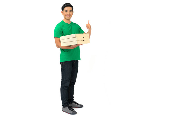 Усміхнений працівник доставки чоловіка в порожній формі футболки стоїть з кредитною карткою, даючи замовлення на їжу і тримаючи коробки для піци ізольовані на білому тлі
 - Фото, зображення