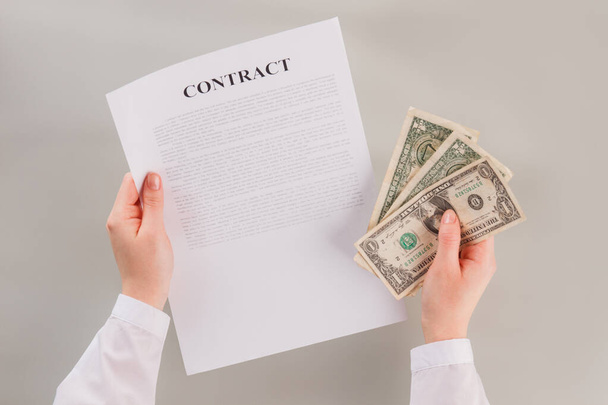 Document and money in womans hand. - Photo, image