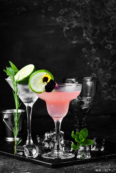 Strawberry alcoholic drink in a glass Margarita. On a black stone background. Menu bar. - 写真・画像