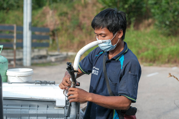 Muadzam Shah, Malasia - 3 de octubre de 2020: Técnicos de aire acondicionado revisando, reparando y manteniendo el servicio de aire acondicionado en la unidad doméstica - Foto, Imagen