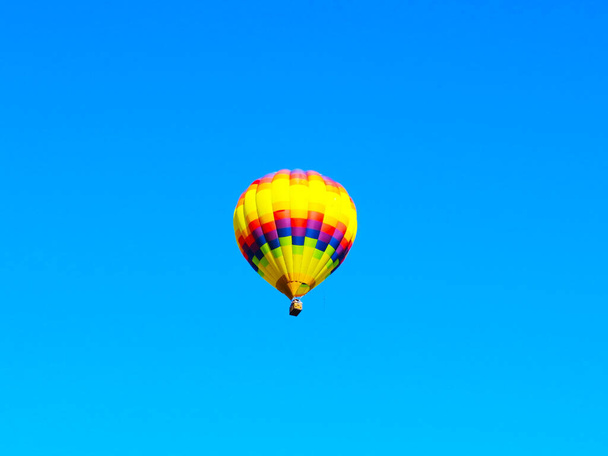 Πολύχρωμο μπαλόνι flyng στον γαλάζιο ουρανό  - Φωτογραφία, εικόνα