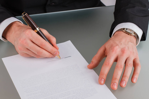 Zakenman handen ondertekenen contract op bureau. - Foto, afbeelding