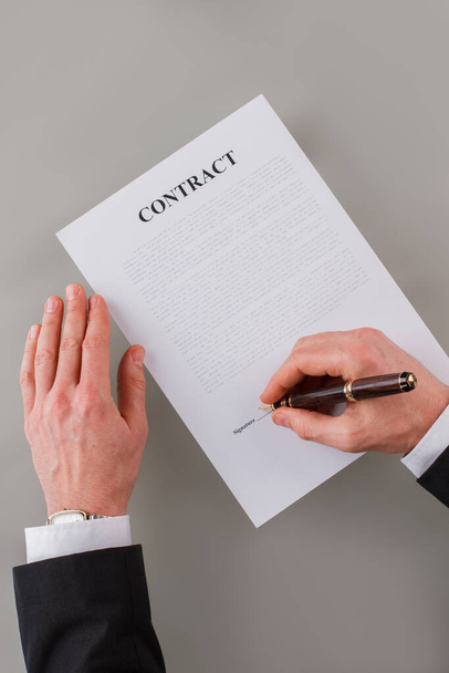Top view of male executive signing a business contract. - Фото, изображение