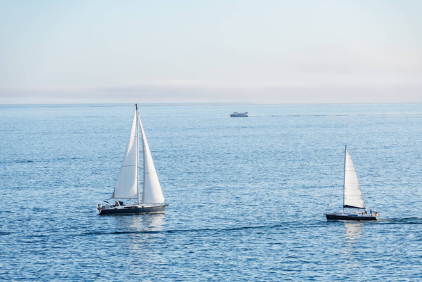 Kaksi purjeveneitä ja lautta tulla ja lähteä Ria de Pontevedra Galiciassa hämärässä. - Valokuva, kuva