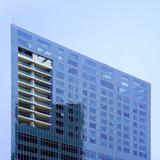 Nowoczesne budynki biurowe drapaczy chmur przeciwko błękitnemu niebu. Wysoki budynek. Nowoczesna architektura miejska. Domy ze szkła i betonu. Widok drapaczy chmur z dołu. - Zdjęcie, obraz