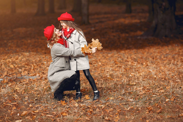 Cute and stylish family in a autumn park - Foto, afbeelding